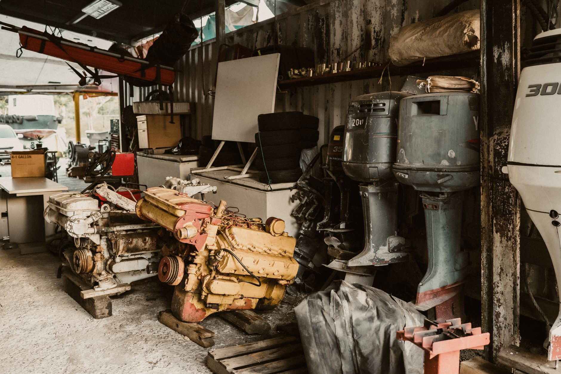 Moteurs et moteurs hors-bord alignés dans un atelier de réparation encombré